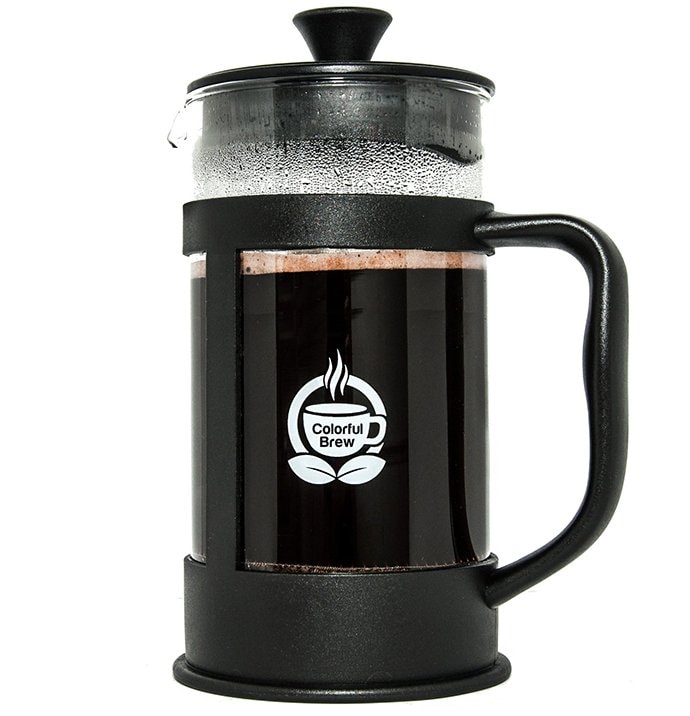 French press filled with coffee in a white background