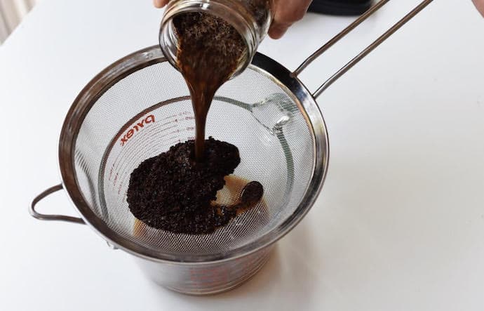 Straining out large grounds with metal strainer