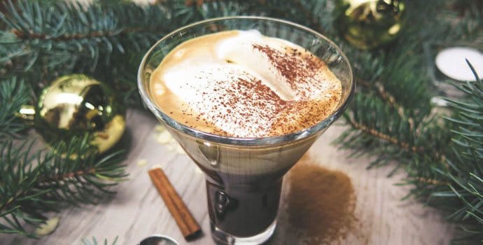 a photo of delicious coffee drink on a table with a Christmas tree branches