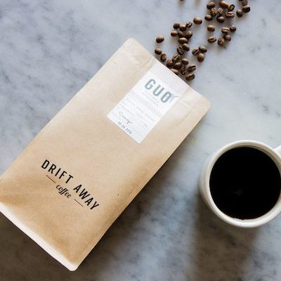 A pack of coffee beans besides a coffee mug