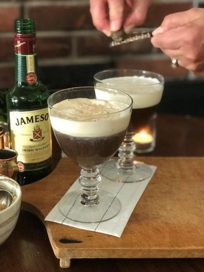 garnishing two coffee glasses with a nutmeg