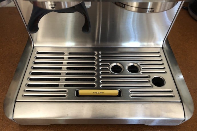 Sign saying its time to empty the tray on the machine