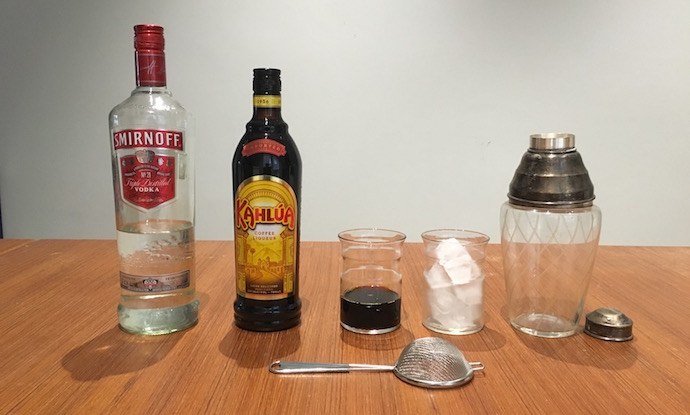 vodka, Kahlua, cold brew, ice cubes, siphon and mixer on a kitchen table