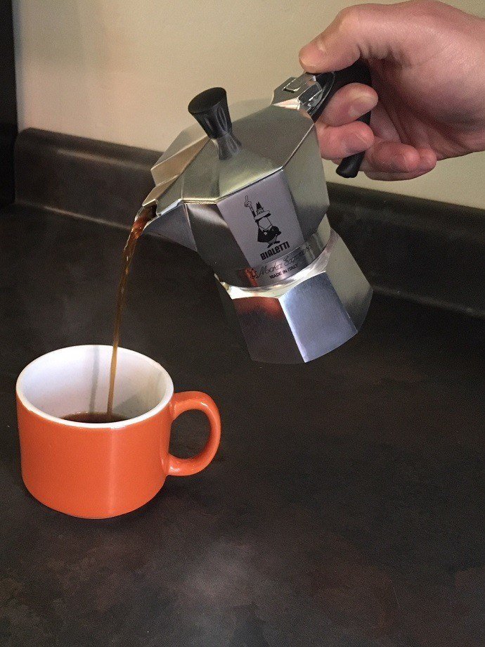 hälla kaffe i en orange kopp