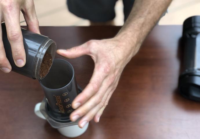 adding coffee to aeropress in preperation of brewing