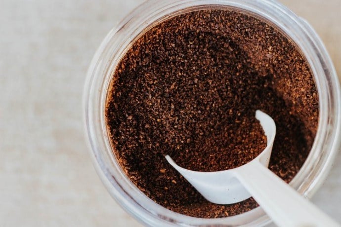ground coffee and a scoop in jar