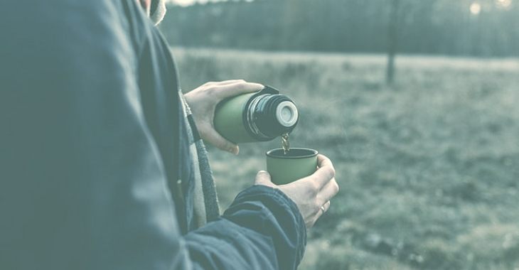 Pouring coffee into a green thermos