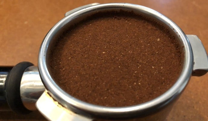 flat bed of coffee grounds in a portafilter