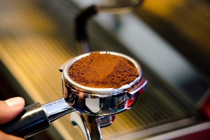 Espresso in a portafilter, which brews the strongest coffee pound for pound