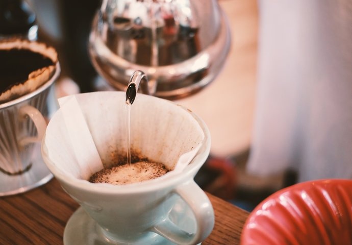 Water pouring on fresh ground coffee from best pour over kettle