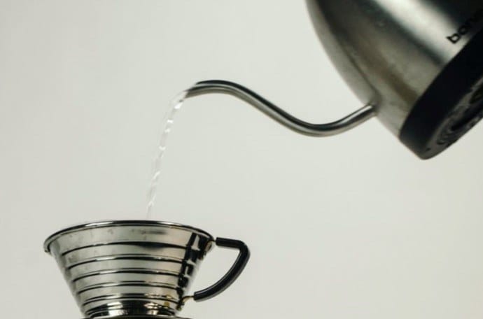 water pouring out of a  gooseneck kettle and into the kalita wave dripper