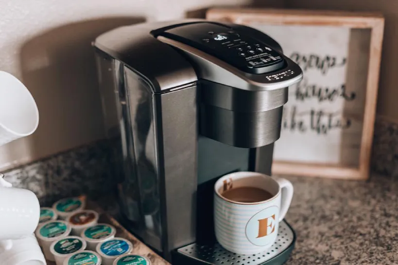 Black Keurig K-Elite on kitchen counter with selection of K-Cups