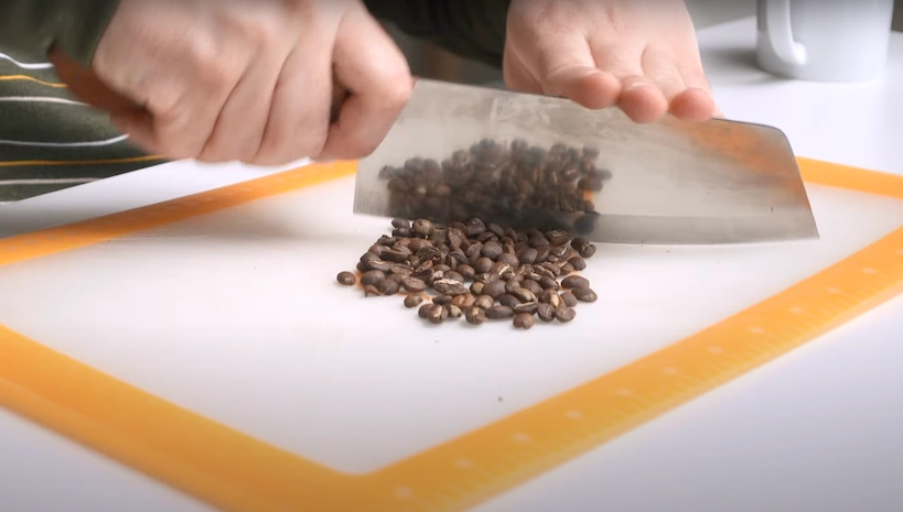 a closeup of a knife chopping coffee beans