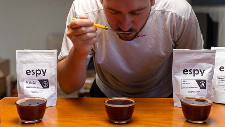 tasting the coffee with a tea spoon