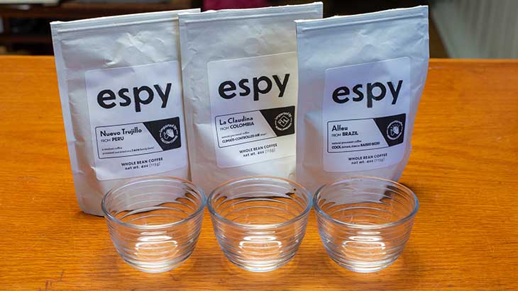 three glasses lined up in front of the three espy white bags