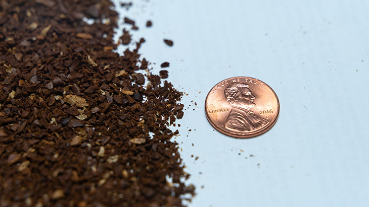 medium course coffee grind with a penny for scale