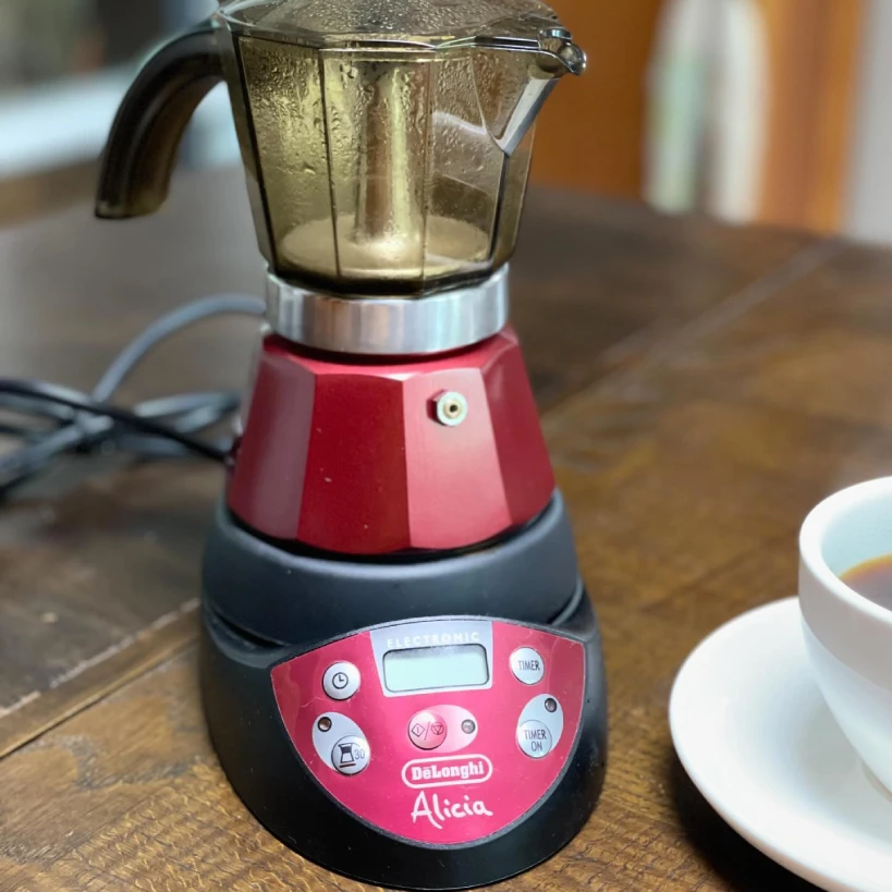 Delonghi Alicia Moka in red with coffee cup