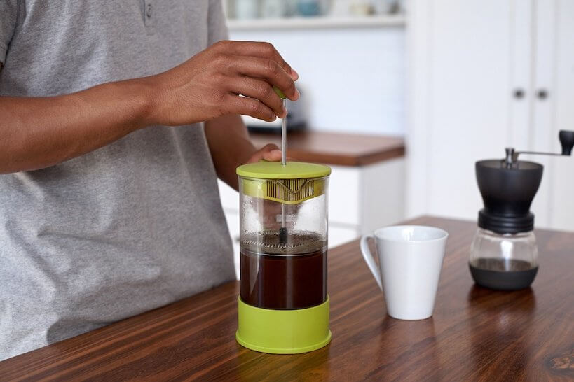 person is plunging coffee in the kitchen