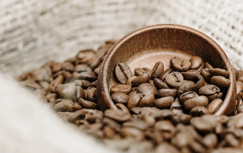 Coffee beans and wooden scoop in paper bag