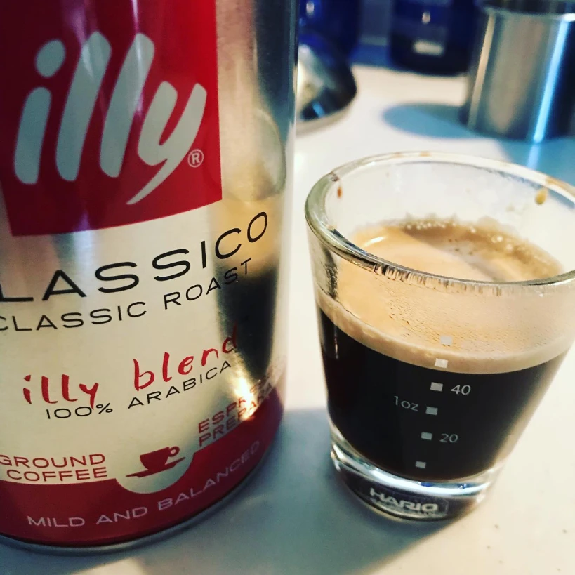Can of Illy Classico coffee with glass of espresso