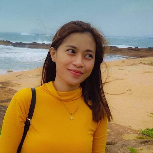 Lei at the beach in a yellow shirt