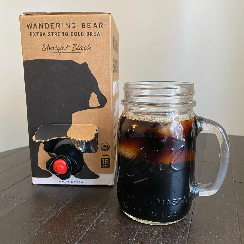 Carton of Wandering Bear cold brew with mason jar