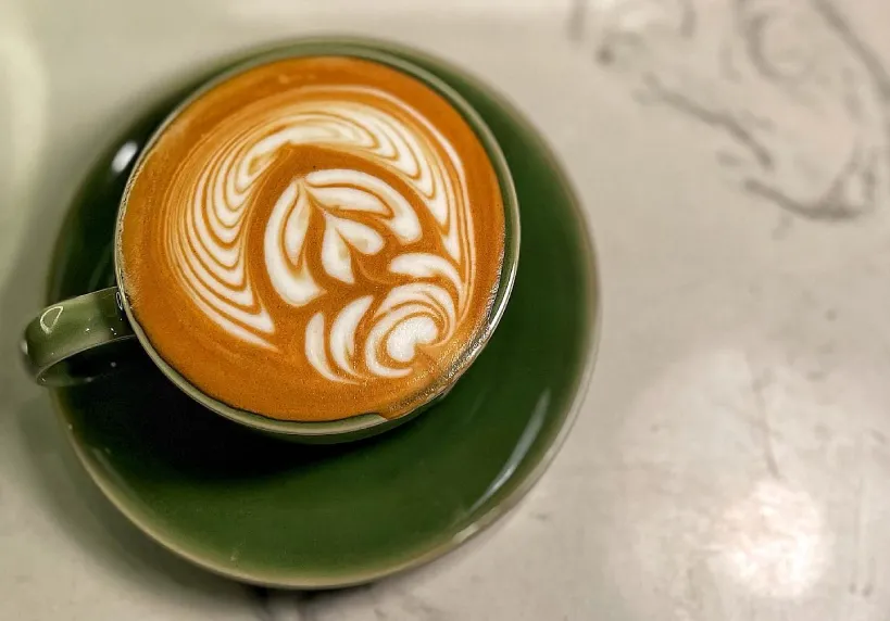 Coffee with latte art in green cup