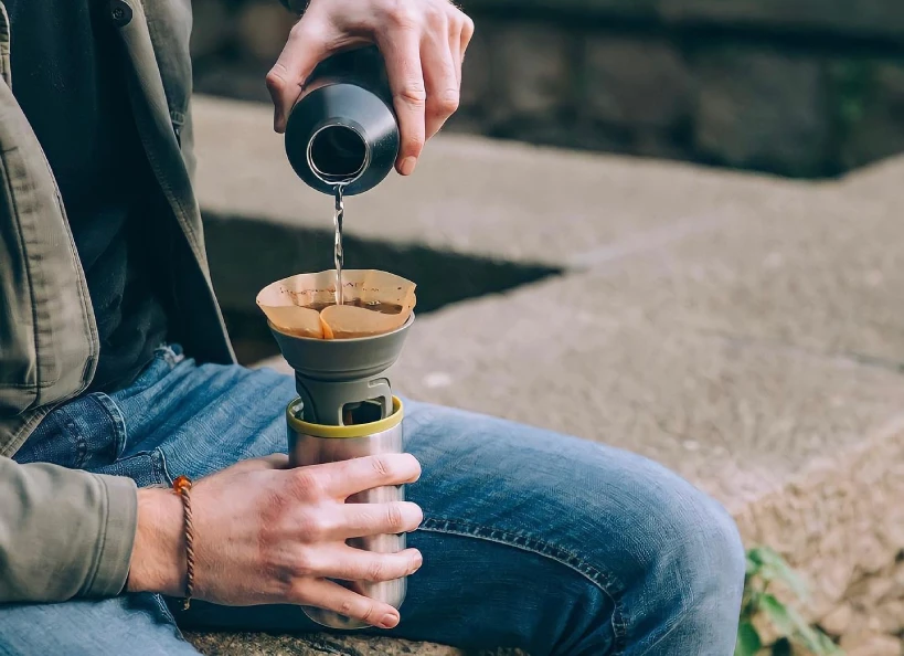 Person pouring water into Wacaco Cuppamoka outside