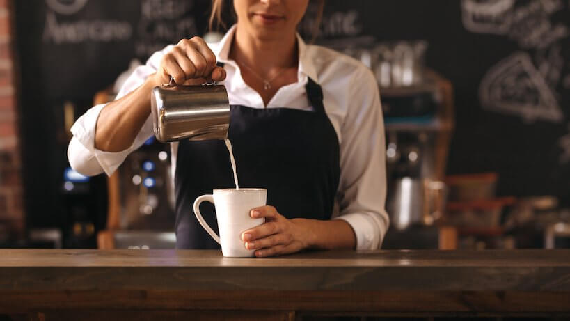 Women Pouring milk in coffee