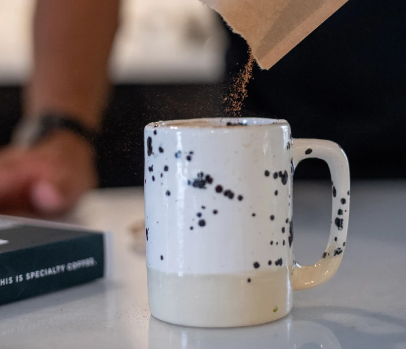 Pouring instant coffee powder from sachet into mug