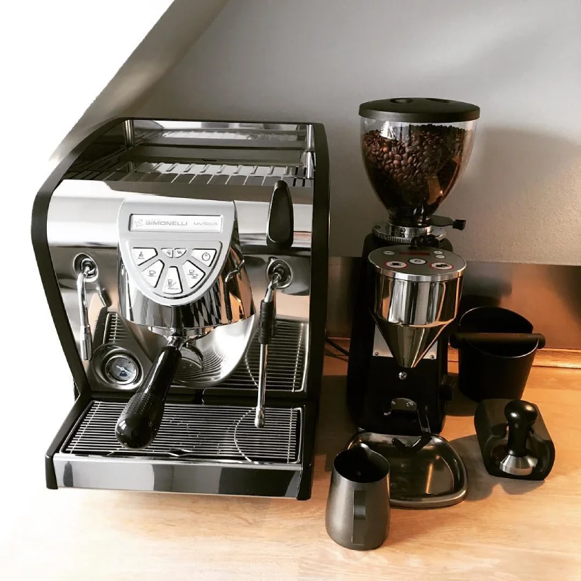 Nuova Simonelli Musica on bench with coffee grinder